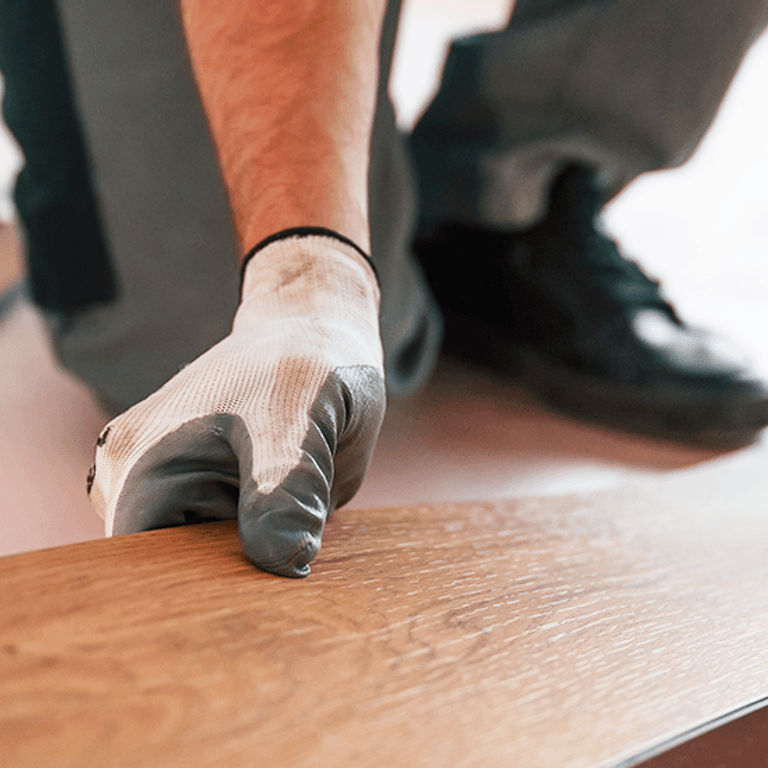 A person is cutting a piece of wood with a saw.